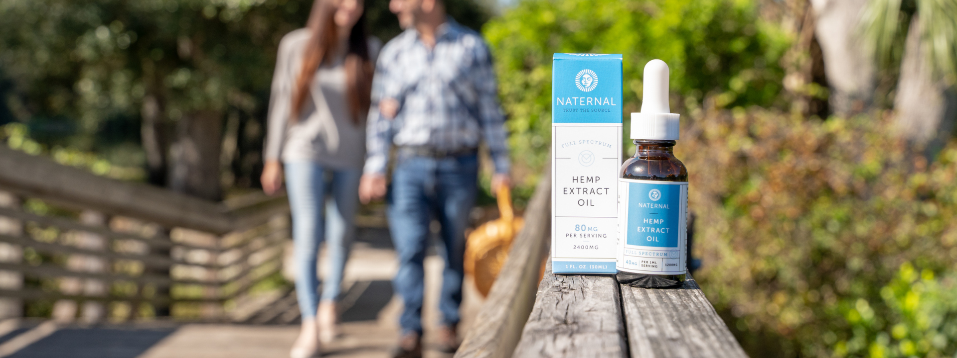 Full spectrum tincture on bridge railing as couple walks past