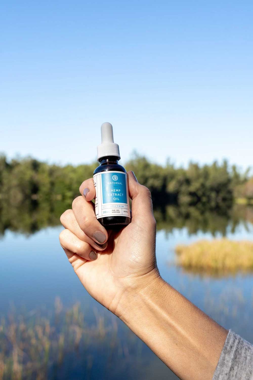 A hand holding a bottle of Full Spectrum CBD Oil 2400mg