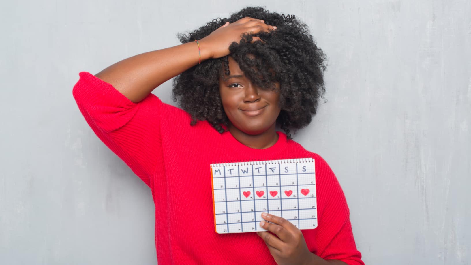 Woman holding up her menstrual cycle calendar