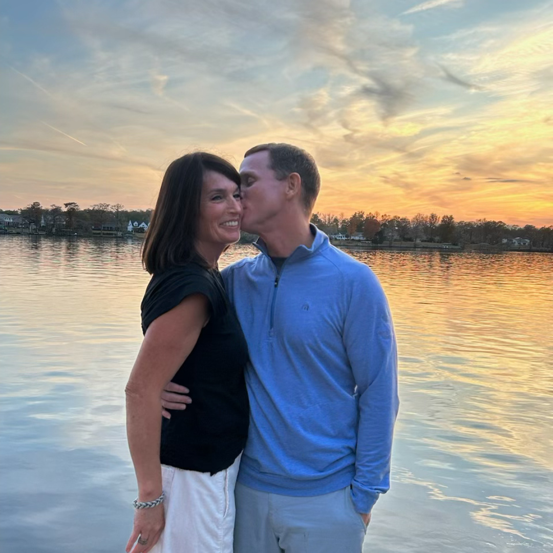 Garrett and April Perdue by the water at sunset